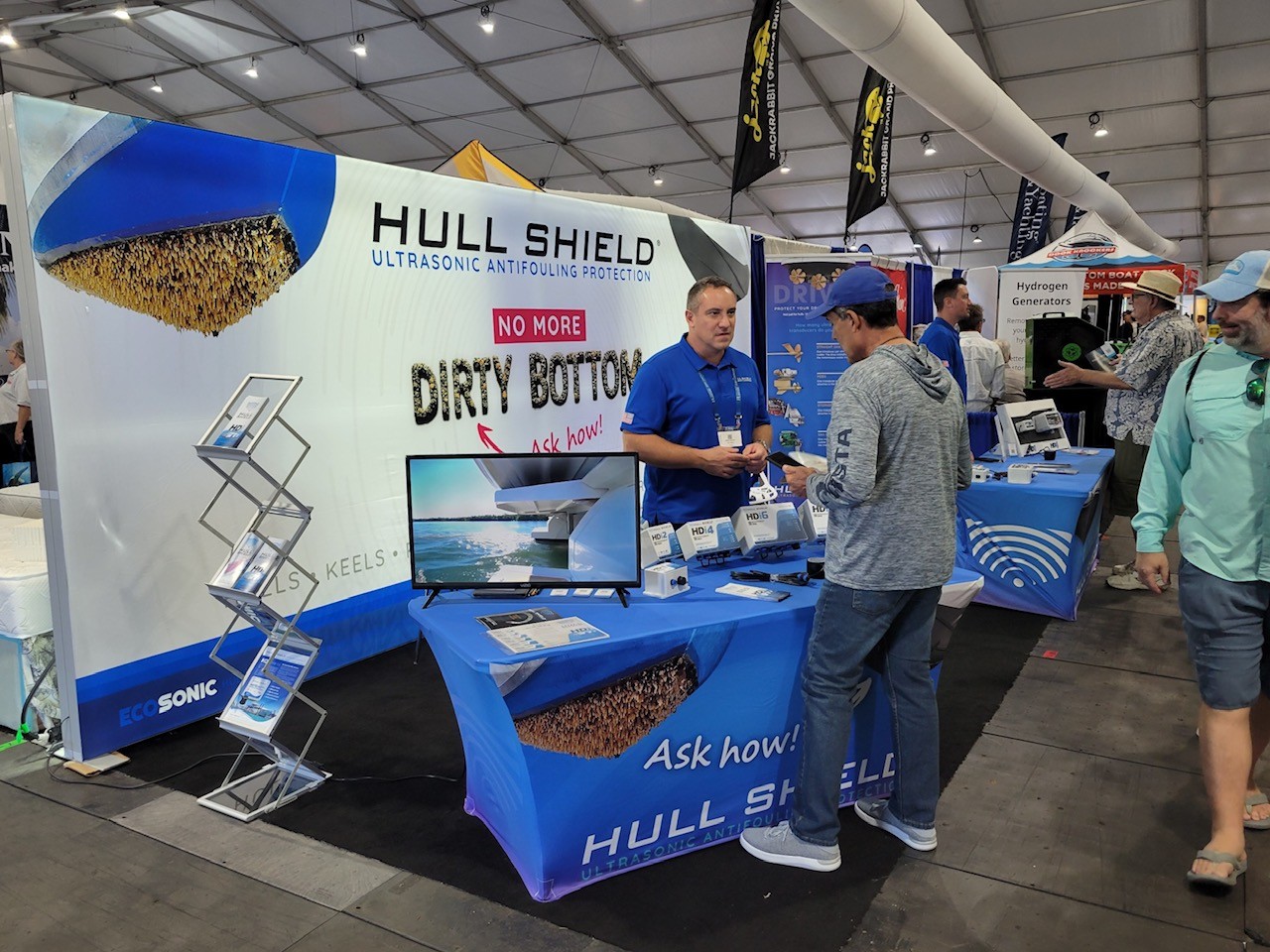 Hull Shield ultrasonic antifouling booth at a boat show, with the No More Dirty Bottom display and HDi controllers on the table